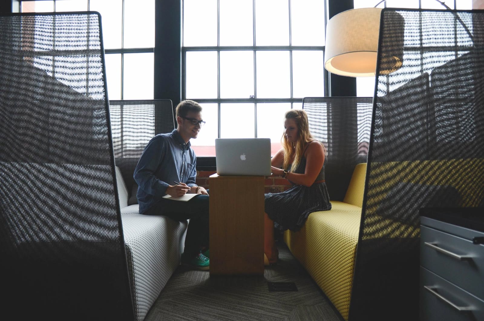 A debt specialist reviewing a client's balances and budget together at a laptop